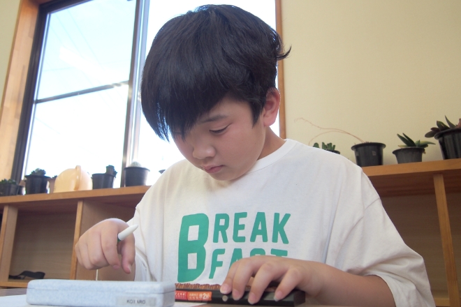そろばんを使って計算する男の子